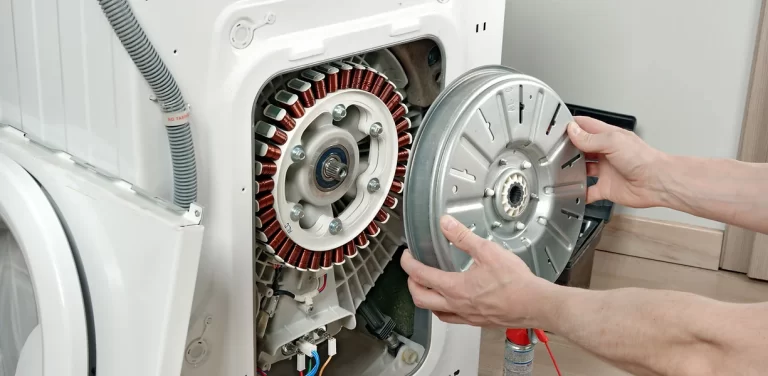 man replacing part on appliance