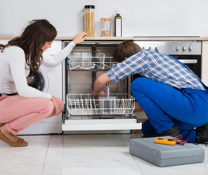 man and woman repairing an appliance